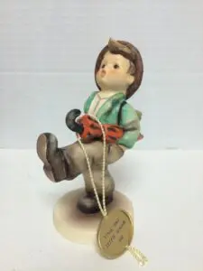 Ceramic boy figurine holding an umbrella.