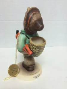 Figurine of child with basket and hat.