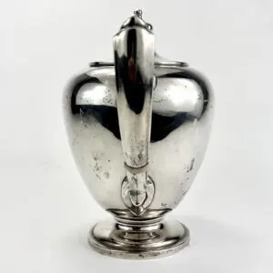 Silver teapot with elegant curved handle.