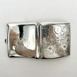Engraved silver cigarette case with initials.