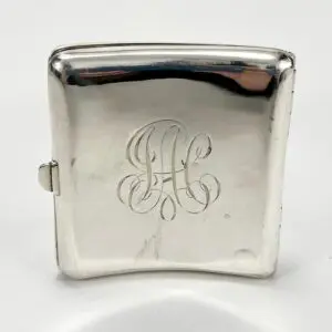 Silver cigarette case with engraved initials.