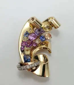Gold brooch with colorful gemstones and diamonds.