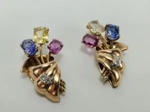 Gold brooches with colorful gemstone accents.