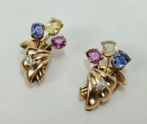 Gold brooches with colorful gemstones and diamonds.