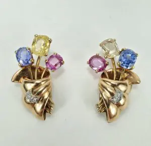 Gold earrings with colorful gemstone flowers.