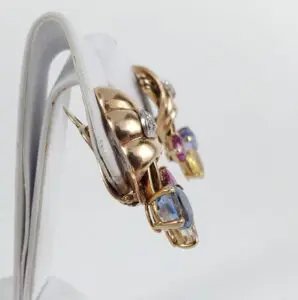 Gold earrings with colorful gemstones displayed.