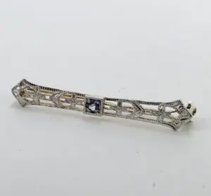 Intricate silver bar brooch with gemstone.