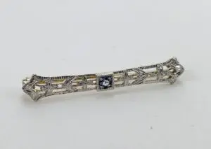 Ornate silver brooch with central gemstone.