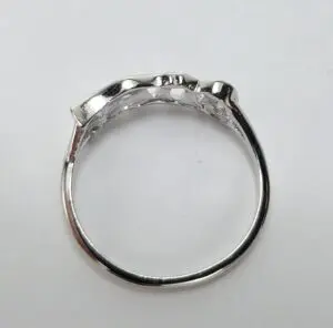 Silver ring with textured design, white background.