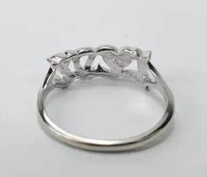 Silver ring with heart-shaped design underneath.