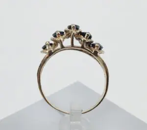 Gold ring with black gemstone accents.