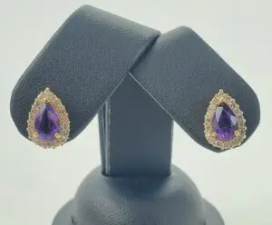 Gold and amethyst teardrop earrings display.