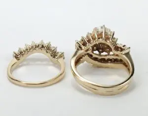 Gold rings with intricate prong settings displayed.