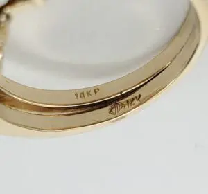 Gold ring with engraved markings inside band.