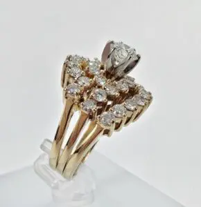 Gold diamond cluster ring with solitaire centerpiece.