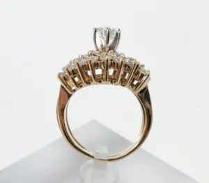 Gold ring with diamond on display stand.