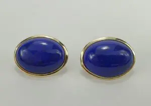 Gold-trimmed blue oval cufflinks on display.
