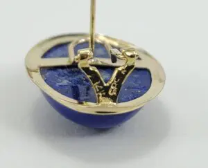 Gold and blue gemstone pin close-up.