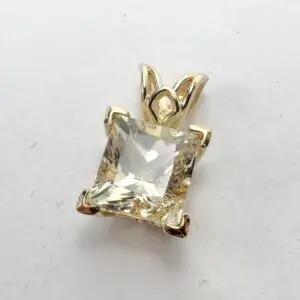 Gold pendant with a square gemstone.