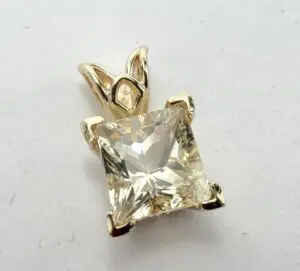 Gold pendant with square-cut clear gemstone.
