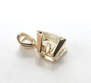 Gold pendant with geometric design on white.