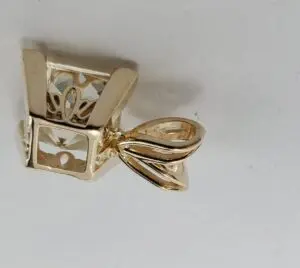 Gold pendant with intricate design details.