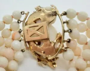 Gold clasp with white beaded bracelet.