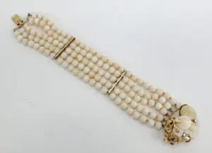 White beaded bracelet with floral clasp.