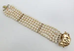 White beaded bracelet with gold clasp.