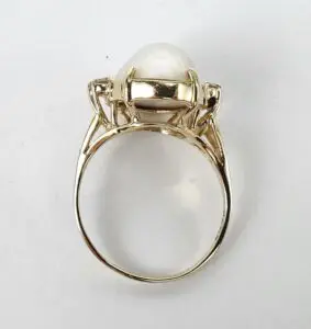 Gold ring with a large pearl setting.