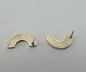 Two gold earring backs, labeled 14K.