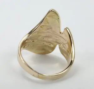 Gold abstract-shaped ring on white background.