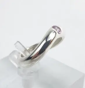 Silver ring with small purple gemstone.