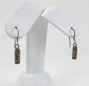 Colorful rectangular earrings on display stand.