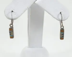 Geometric stone inlay earrings on display stand.
