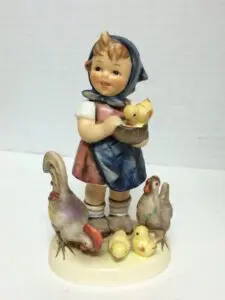Child figurine with chickens and chicks.