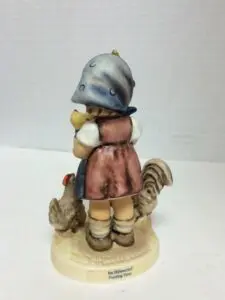 Girl statue with chickens and rooster.