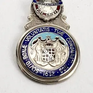 Silver medal with intricate engraved design.