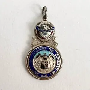 Silver and blue vintage medallion with inscriptions.