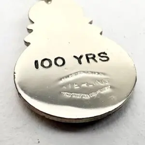 Snowman-shaped metal tag, "100 YRS" engraved.