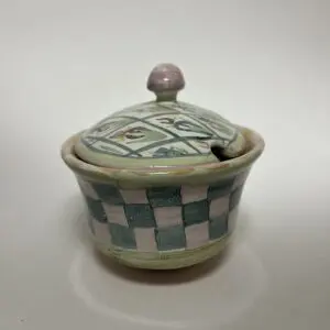 Ceramic container with lid and checkered pattern.