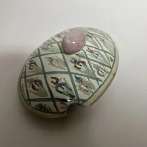 Decorative ceramic lid with floral pattern.