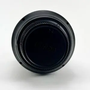 Nikon lens cap on white background.