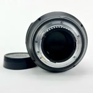Camera lens with cap on white background.