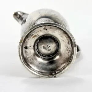 Bottom view of a silver teapot base.