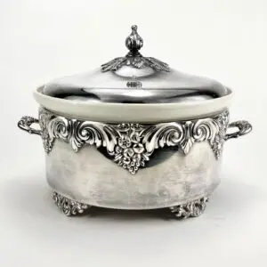 Ornate silver tureen with decorative handles.