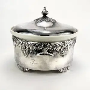 Ornate silver container with lid and engravings.
