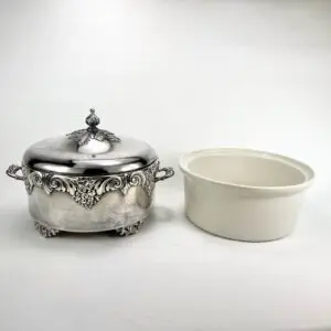 Silver serving dish with white ceramic insert.
