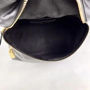 Open black leather handbag with gold zipper.