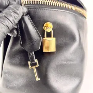 Black leather bag with gold lock and key.